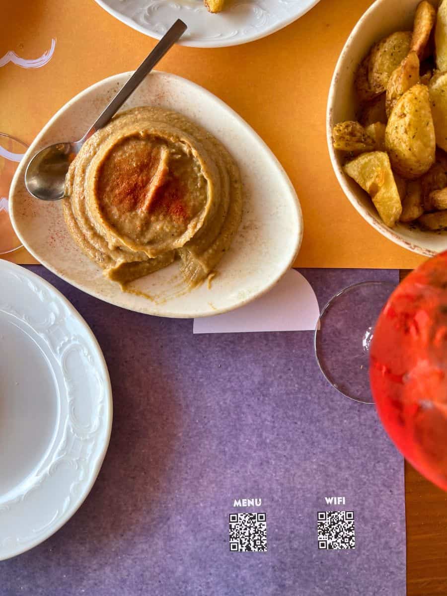 solo travel Mykonos dining. Hummus and a drink on the table