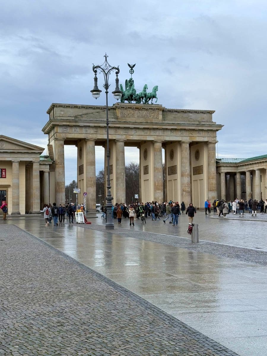 Brandenburg Gate in Berlin, a historic landmark and a symbol of unity. The scene bustles with tourists, underlining the city's lively and welcoming atmosphere.
