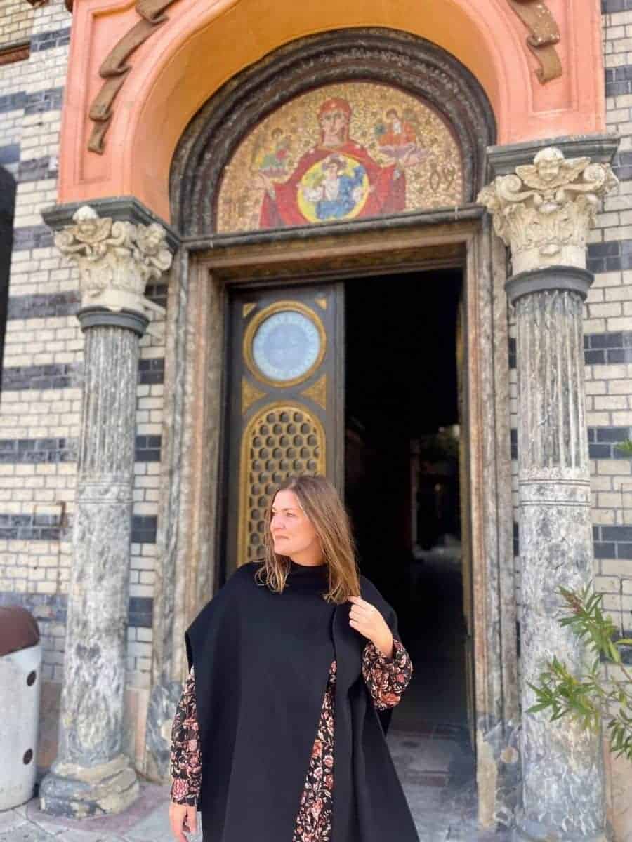 A woman in Romania alone in front of a brick church