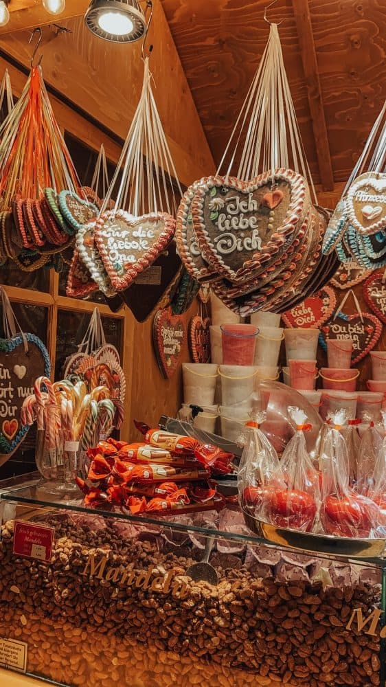 A cozy Christmas market stall in Berlin, filled with heart-shaped decorations and red festive ornaments.