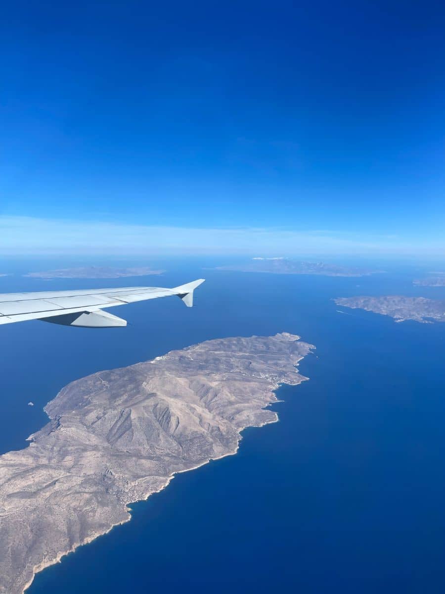 A plane wing in air with the Greek island showing below