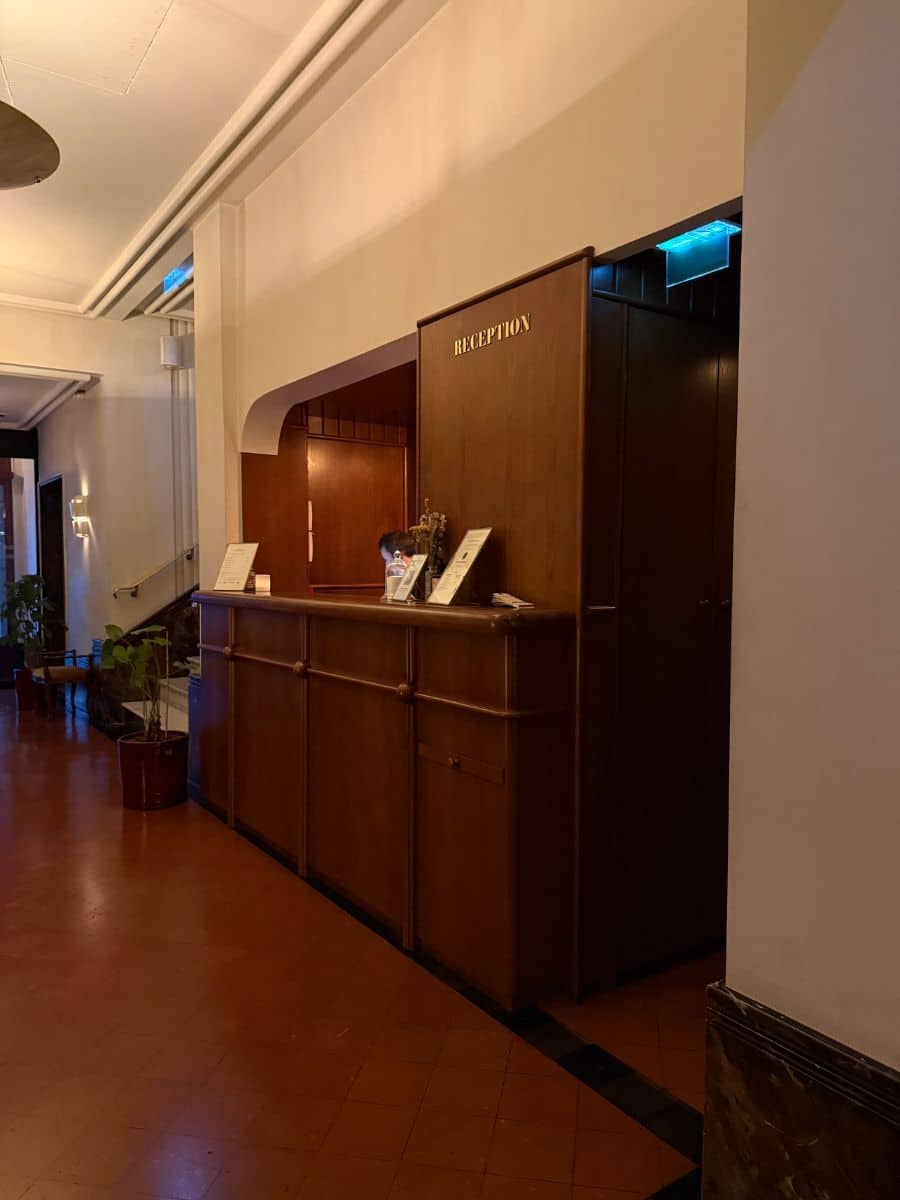 Reception desk of a dog-friendly hotel in Paris, featuring a welcoming environment with a minimalist design and warm lighting.