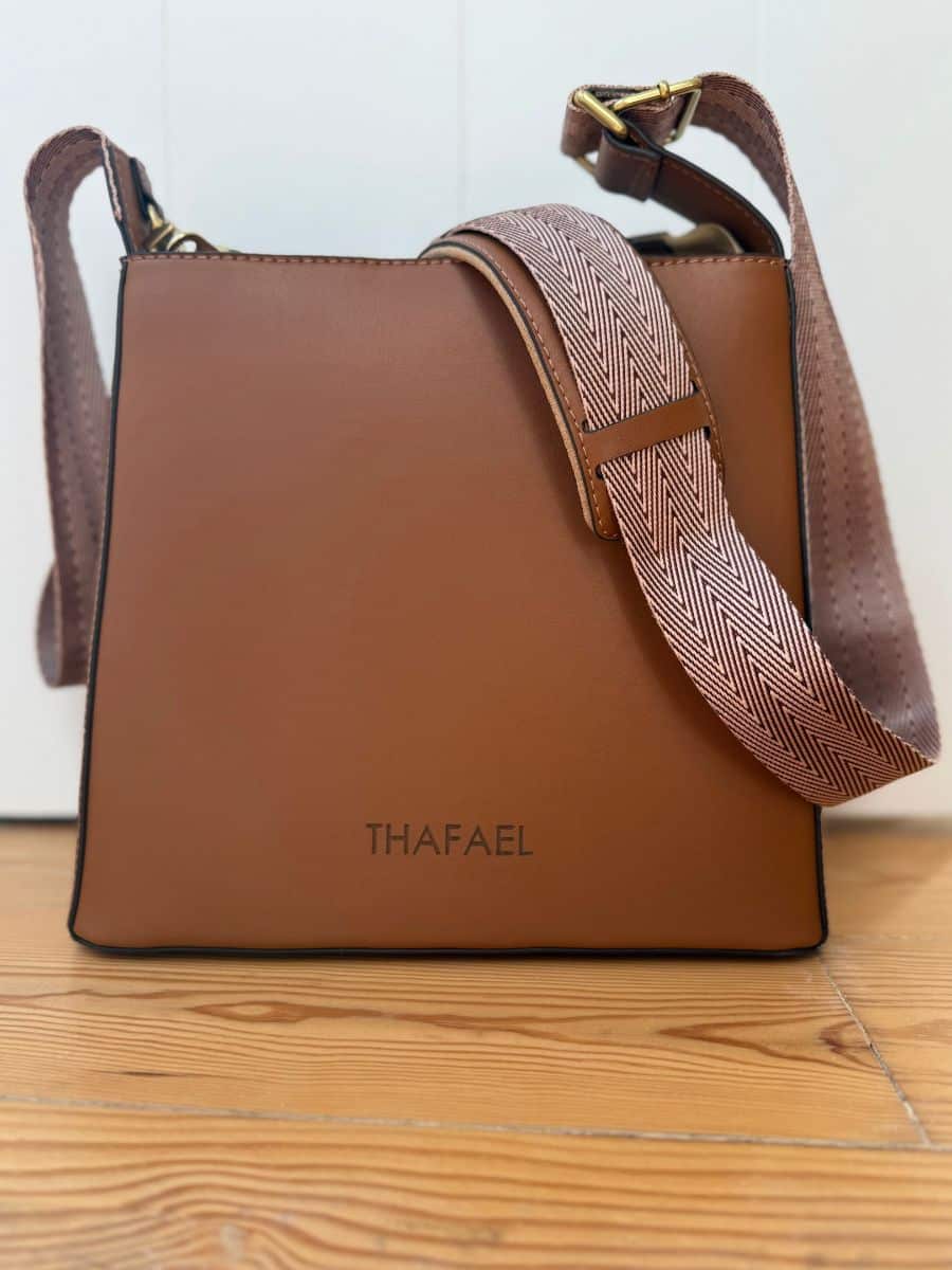 Minimalist design with the brand name "THAFAEL" on a structured, stylish purse.
