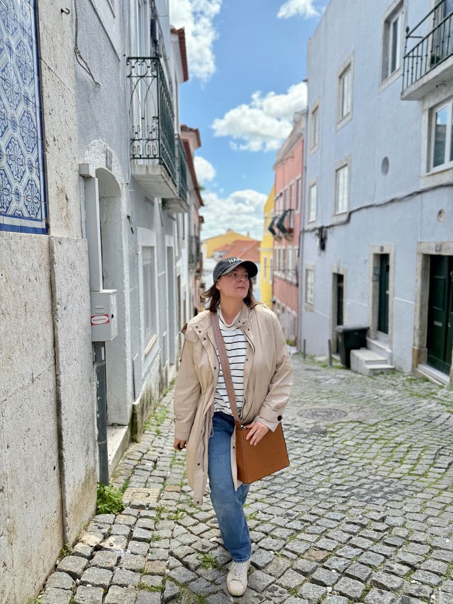 Exploring a quiet European street with a brown shoulder bag designed for safety and travel ease.