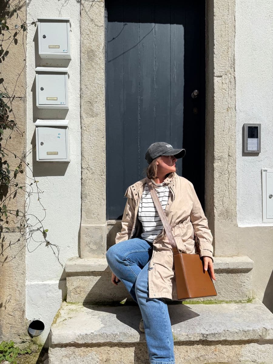 Relaxing moment outside a dark door, featuring a travel-friendly security purse.