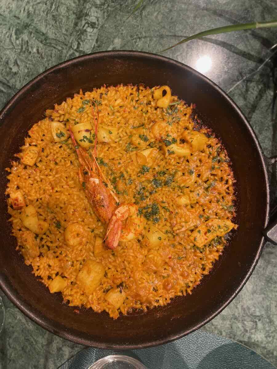 Close-up of a traditional Valencia paella with shrimp and calamari, showcasing a must-try dish for savoring authentic Spanish flavors.