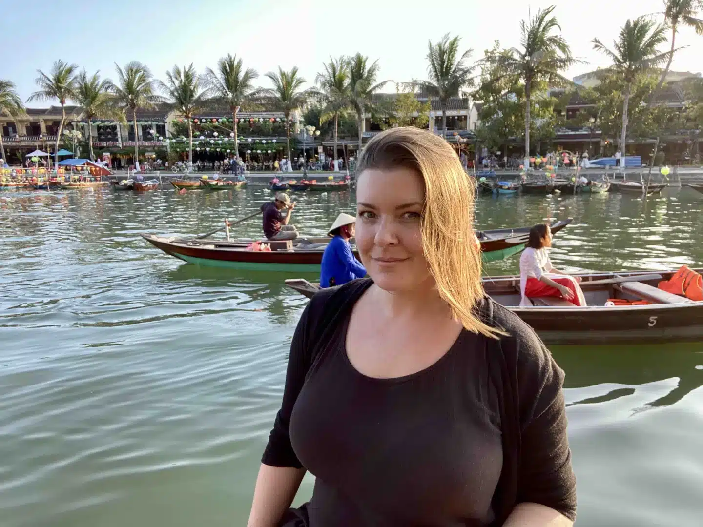 a woman solo traveling in her 30s in Asia. The lake with canoes in the background